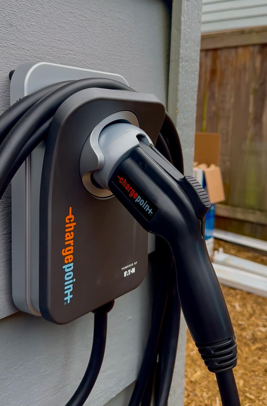 Electric vehicle charging station with ChargePoint plug attached to a wall.