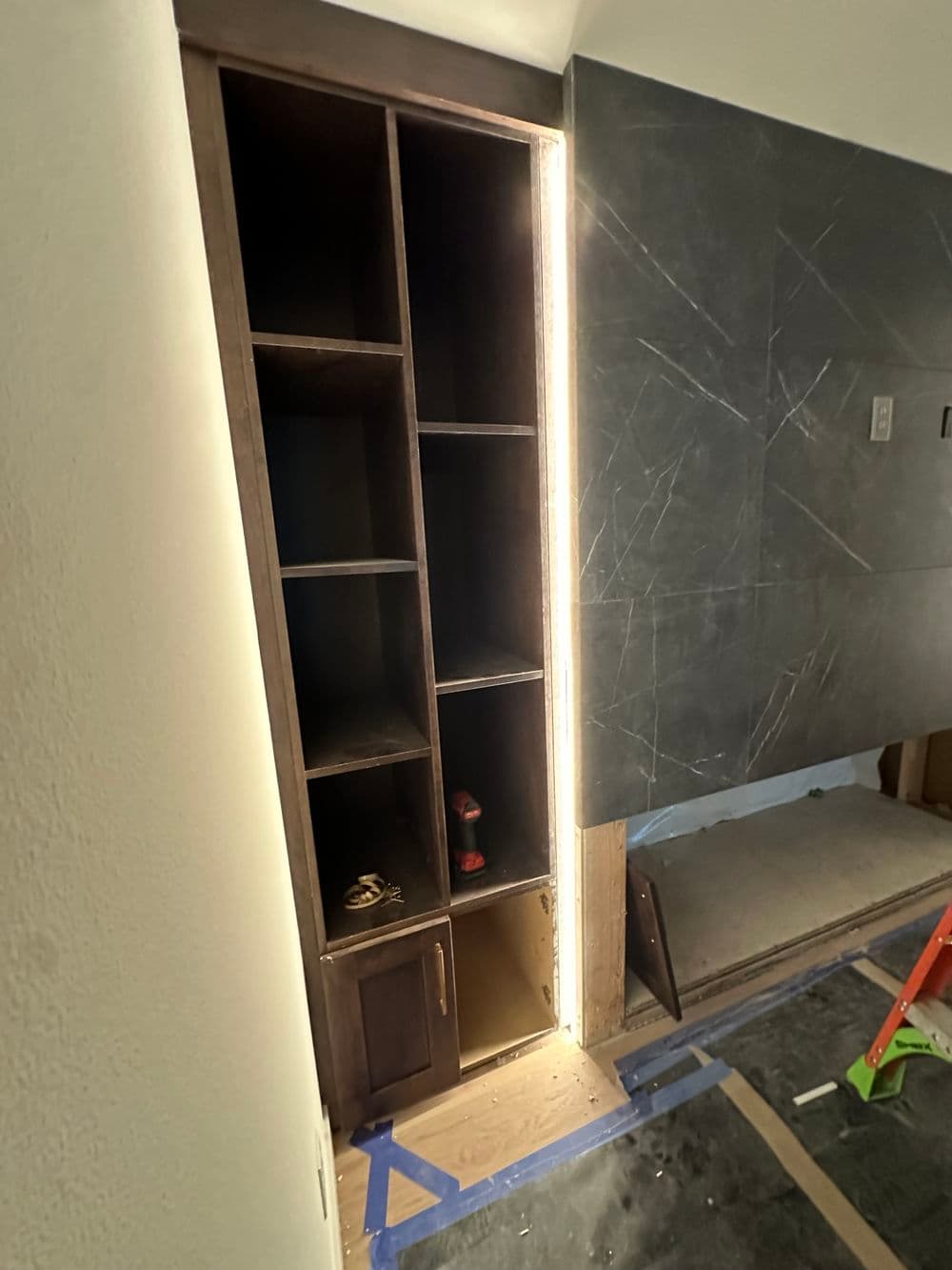 Modern wooden cabinet with LED lighting and open shelving in a stylish interior.