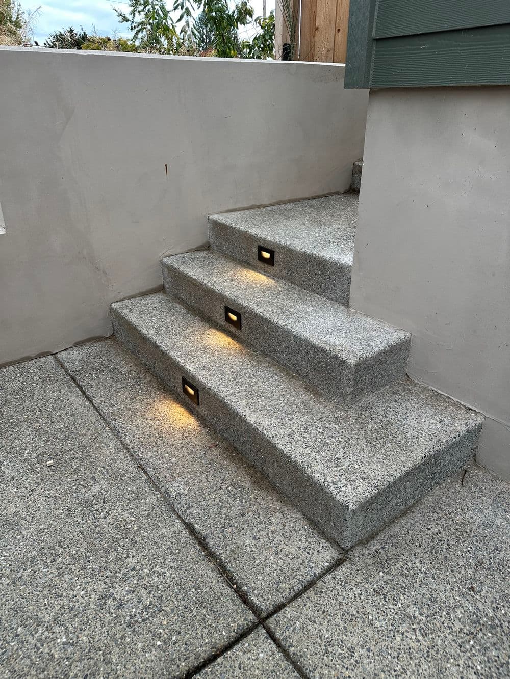 Concrete outdoor stairs with lights, leading up to a building entrance.