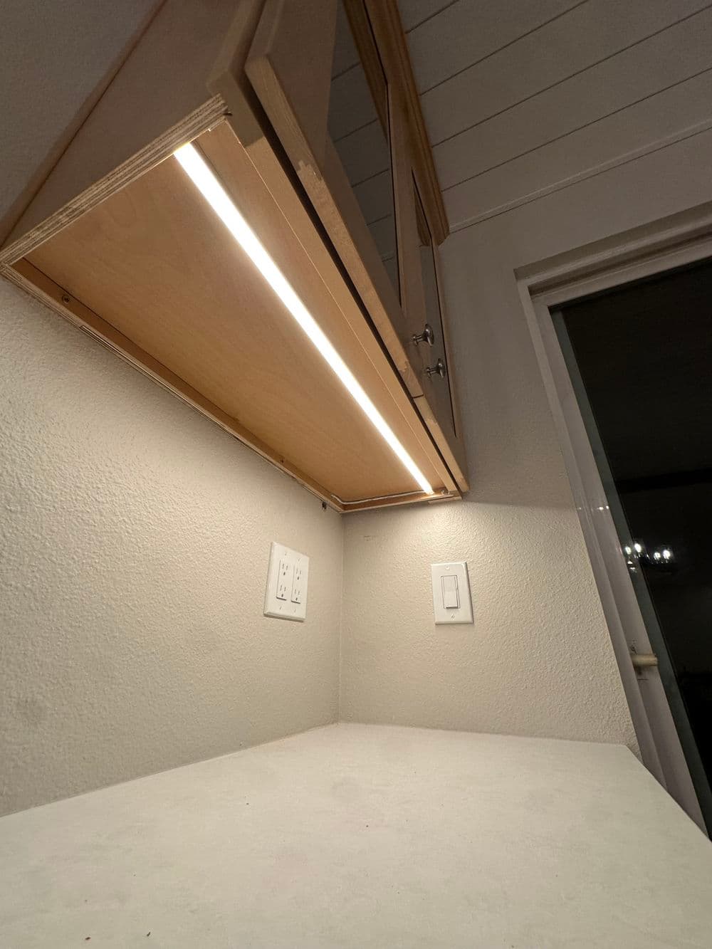 Modern kitchen cabinet with under-cabinet lighting and a clean countertop.