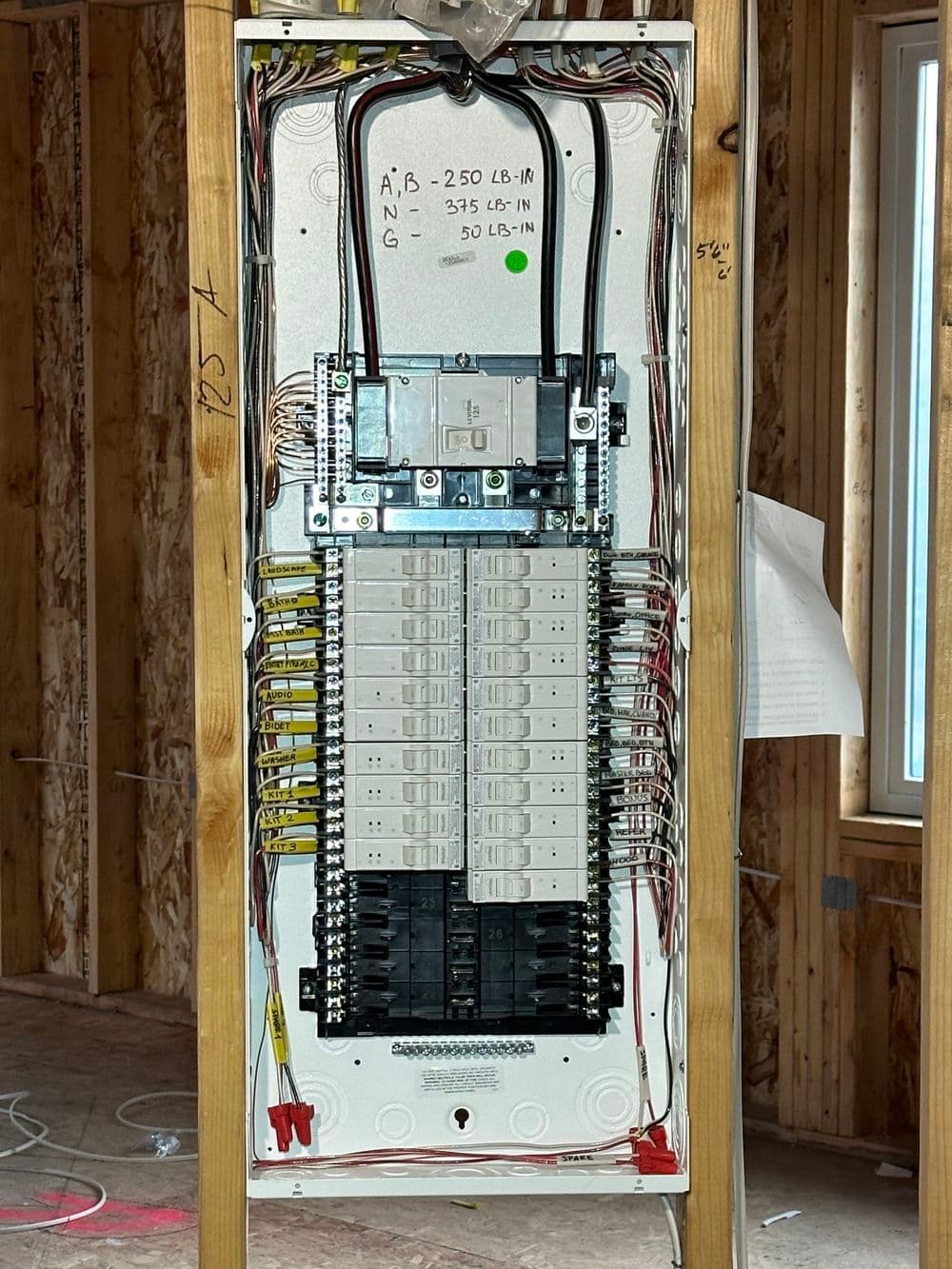 Electrical panel installation in a new home with organized wiring and circuit breakers.
